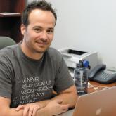 Chad Casselman at his desk with laptop - Alumni Profile