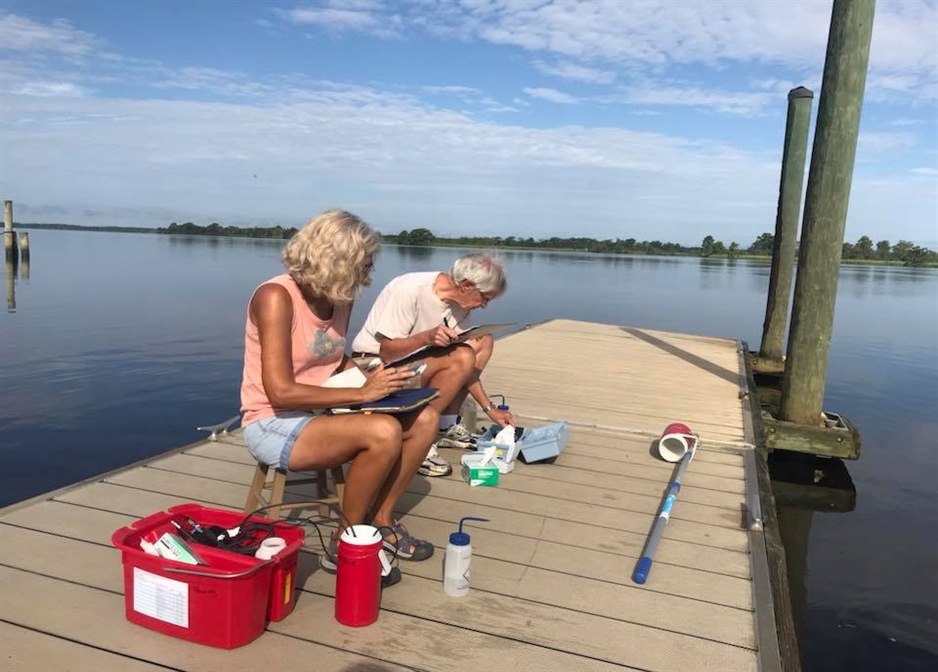 A photo of two volunteers sampling on a dock