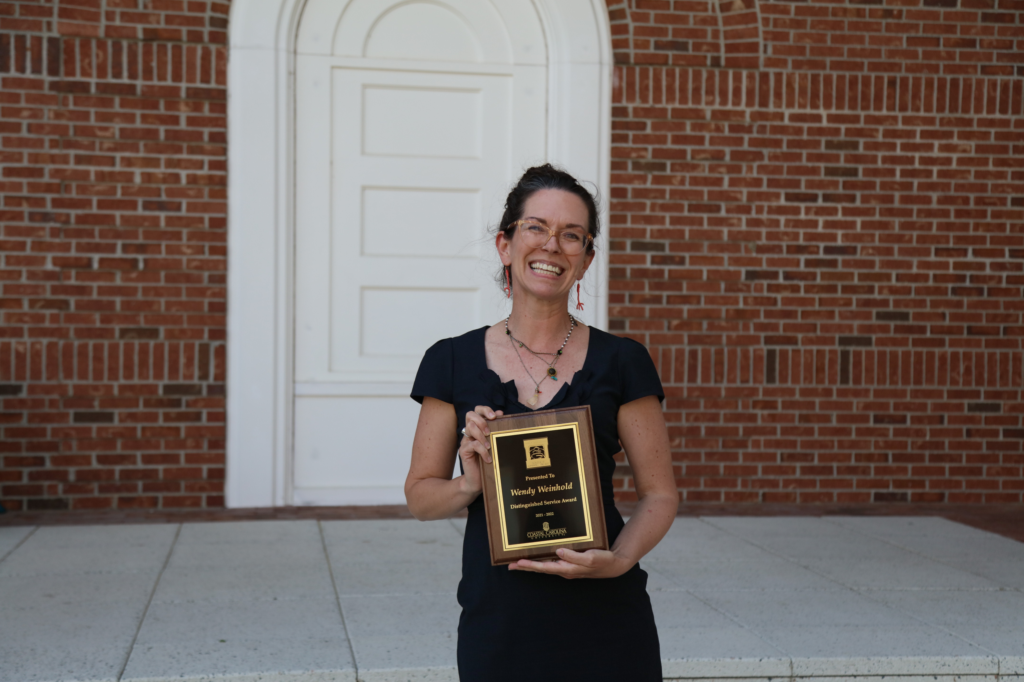 Image of Dr. Wendy Weinhold holding an award
