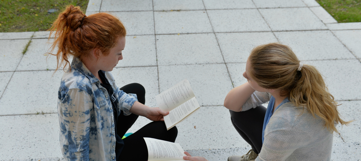 2 female students reading in Edwards Courtyard