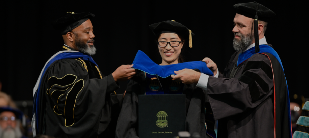Student receiving Ph.D. hood at graduation ceremony